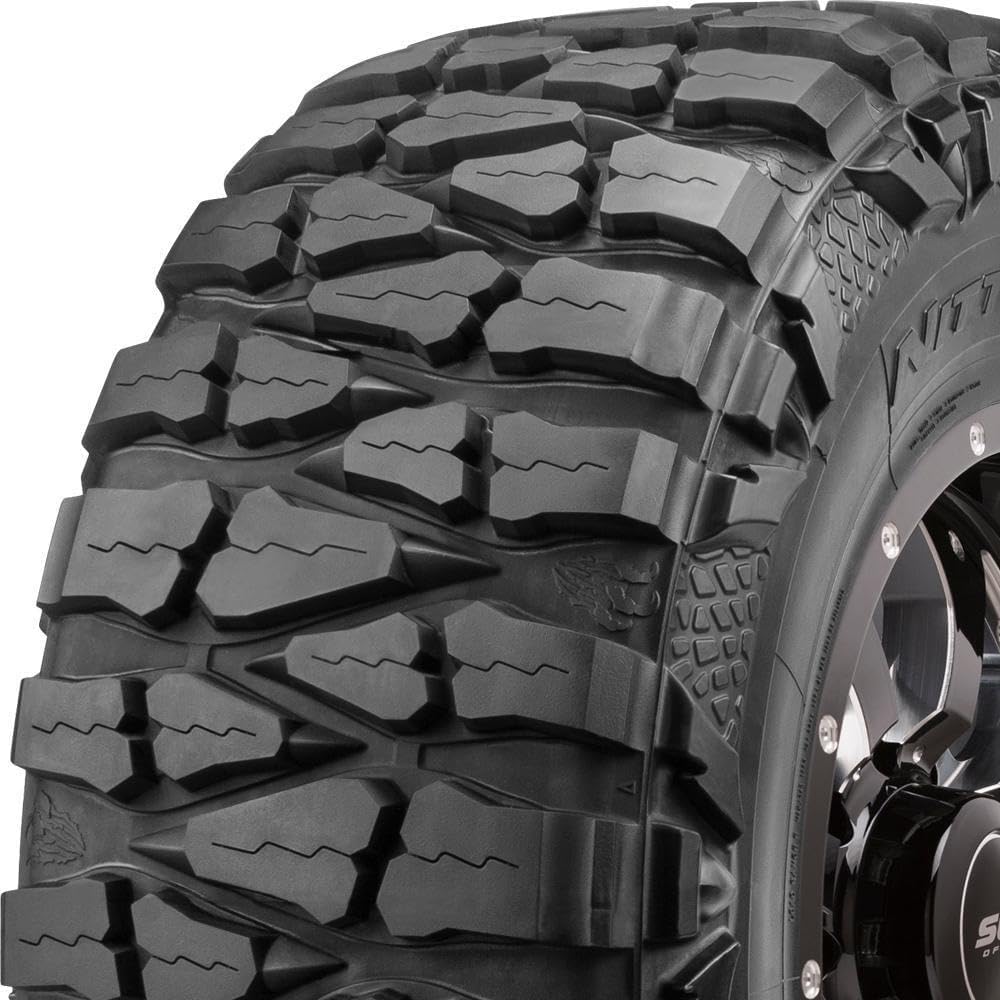 Extreme mud-terrain tire with deep blocky lugs that wrap over the shoulder onto the sidewall, mounted on a black off-road wheel